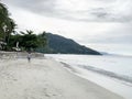 Boy walking on White sand beach at Sunset Aninuan Beach Puerto Galera, Philippines