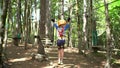 Boy walks across the agility bridge stepping carefully on the crossbeams