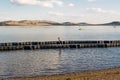 A boy walks on a pontoon on a lake