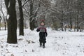 Boy walks in snow-covered winter park. Walking with children in winter