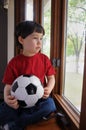 Boy wants to play soccer on a rainy day