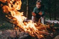 Boy warms hands near the campfire Royalty Free Stock Photo