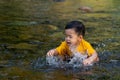 The boy was having fun playing in the water for the first time in the stream Royalty Free Stock Photo