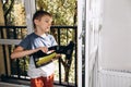A boy washes windows at home using a cordless window cleaner. Selective focus