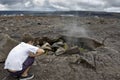 Boy watching steam coming out of lava hole. Royalty Free Stock Photo