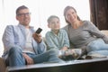 Boy watching TV with parents in living room Royalty Free Stock Photo