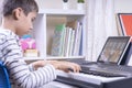 Boy watching video lesson at digital tablet computer and playing piano at home. Online learning remote education Royalty Free Stock Photo