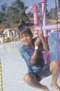 A boy on a water fountain at Raging Waters amusement park, Los Angeles, CA