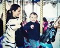 Boy Waving on a Carousel Ride with Mother - Retro