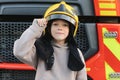 A boy wearing a fireman& x27;s helmet near a fire truck. Royalty Free Stock Photo