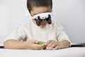 A boy wearing head magnifying glasses