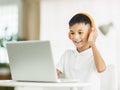 Boy wearing headphones and studying online with laptop Royalty Free Stock Photo
