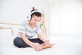 Boy wearing headset listening music and play games from tablet computer on bed