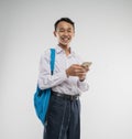 a boy wearing a junior high school uniform smiles while holding a cellphone Royalty Free Stock Photo