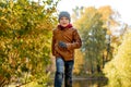 boy wearing leather jacket run in autumn central park in Saint-petersburg, Russia on sunny october day Royalty Free Stock Photo