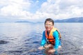 Boy wearing life jacket and sitting in the sea Royalty Free Stock Photo