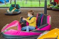 Boy wearing a medical mask during COVID-19 coronavirus having a ride in the bumper car at the amusement park