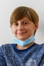 Boy wearing a medical mask smiling on white background, new normal back to school during Covid-19 pandemic