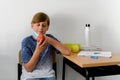 Boy wearing a medical mask about to eat an apple at school, new normal back to school during Covid-19