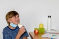 Boy wearing a medical mask about to eat sanwich at school, new normal back to school during Covid-19