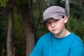 Boy Wearing Old Cap and T-shirt with a Forest Background