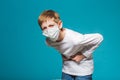 Boy wearing protection mask having stomach ache