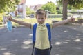 Boy wearing a protective mask with a backpack behind his back in the schoolyard on the first school day after isolation or Royalty Free Stock Photo