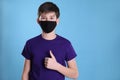 Boy wearing protective mask on light blue background, space for text. Child safety Royalty Free Stock Photo