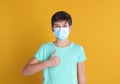 Boy wearing protective mask on yellow background, space for text. Child safety Royalty Free Stock Photo