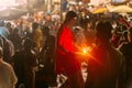 Boy wearing red cloth walking with lighted candle for blessing people in Varanasi Ganga Aarti at Holy Dasaswamedh Ghat.