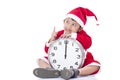 Boy wearing Santa Claus uniform and holding clock