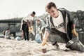 Boy wearing sport jacket walking with garbage bag and cleaning up trash Royalty Free Stock Photo