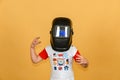 A boy in a welding mask waves his hands in different directions, on a yellow background