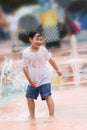 Boy wet and laughing in a fountain square