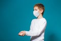 Boy in white protection mask holding pills in hand