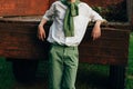 A boy in a white shirt and green pants, a green sweater around his neck, leaning his elbows on the old truck cousin, barefoot on Royalty Free Stock Photo