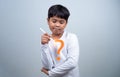 A boy in a white shirt is holding a white pen on a white background. Shows thinking, pondering, and considering options