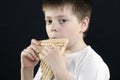 Boy in white shirt playing bamboo panflute Royalty Free Stock Photo