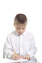 Boy in white writing at table