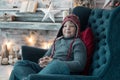 Boy in winter clothes in the chair on holyday background