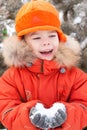 Boy at the winter walk, keeps the snow