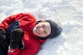 Boy in winterwear laughing while playing in snowdrift outside Royalty Free Stock Photo