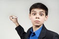 Boy wonder looks with a ballpoint pen Royalty Free Stock Photo