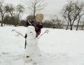 The boy is working diligently sculpts a snowman.