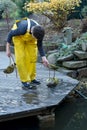 Boy working in the garden, cleaning the pond Royalty Free Stock Photo