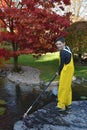 Boy working in the garden, cleaning the pond Royalty Free Stock Photo