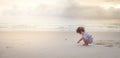 a boy is writing on white sand beach