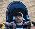 The boy yawns in the blue stoller Royalty Free Stock Photo