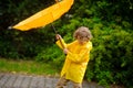 The boy of 8-9 years with effort holds an umbrella from windflaws. Royalty Free Stock Photo