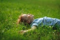 Boy of 8-9 years lies in the field on a green grass. Royalty Free Stock Photo